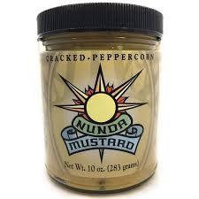Jar of cracked peppercorn mustard with a black lid on a white background